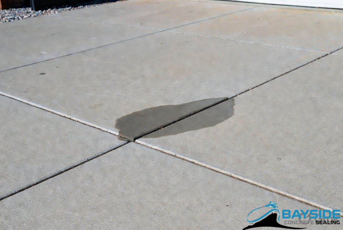 High-strength resin crack repair on a concrete driveway after sealing