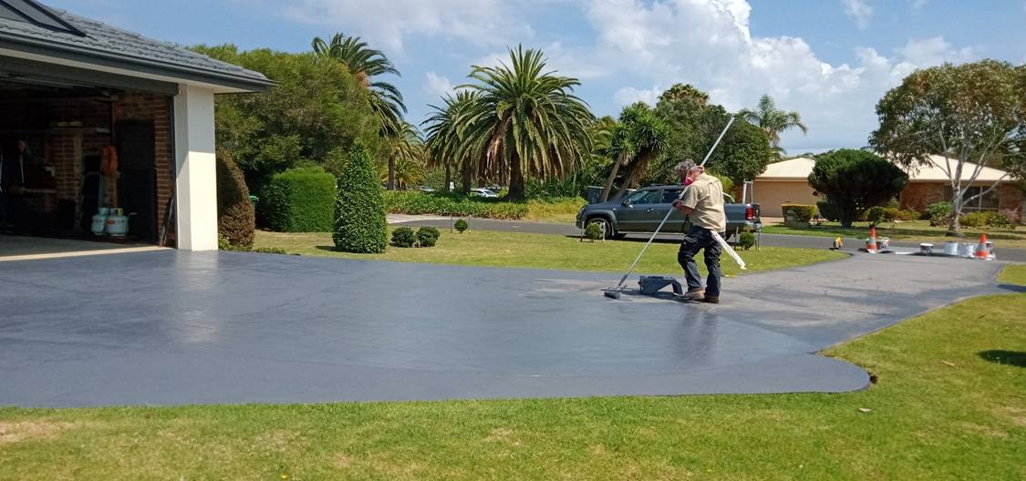 Technician applying driveway sealant on a Melbourne residential driveway